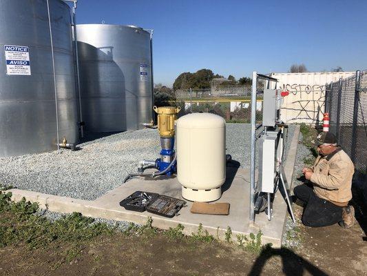 Multiple Storage Tank Installation with booster pump, pressure tank, and VFD well pump/motor.