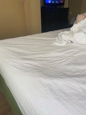 Clearer picture of the large dent in the bed with the dingy dirty sheets