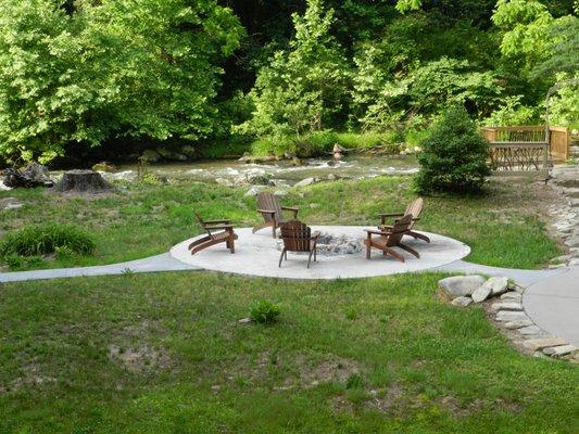 Riverside back yard with fire pit at Grist Mill River Cottage.