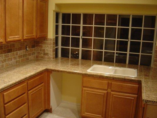 12 x 12 granite countertop tile with a chair rail apron. In 3 x 6 tumbled travertine backsplash with the running bond pattern.