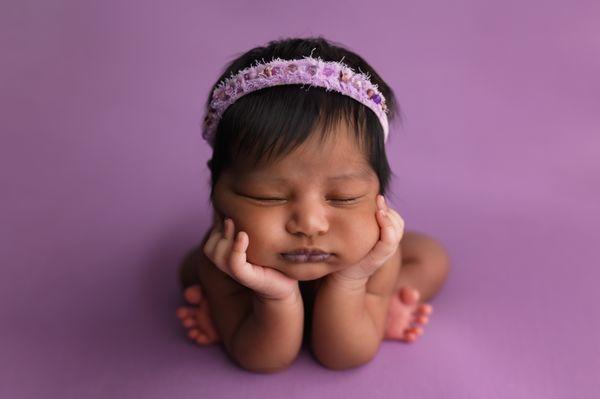 newborn baby girl on purple backdrop