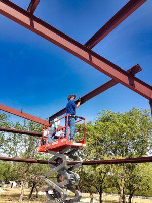 Building our shop was hard work, but the whole family pitched in. Here is shop owner, Evan McDaniel, up on the cherry picker (summer 2013).