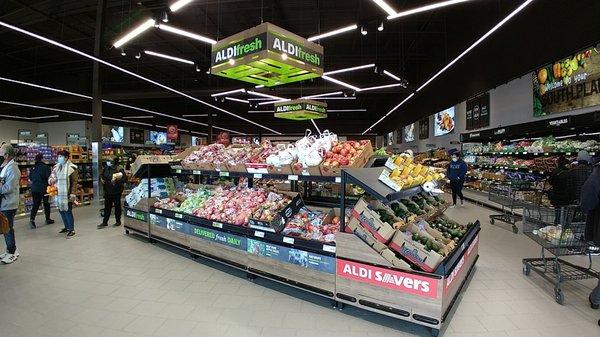 The line to checkout is so long that it bleeds into the produce section.