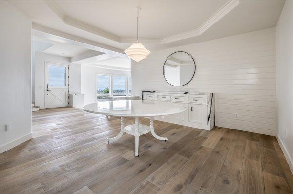 Dining room features: newly remodeled walls, chandelier light fixture, V-groove shiplap accent wall, custom credenza, and new hardwood floor