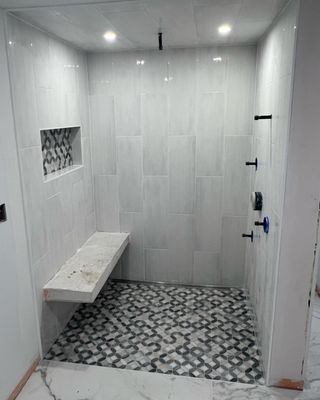 Another Curb-less shower in Boston with Ceiling tile and Stone Bench.