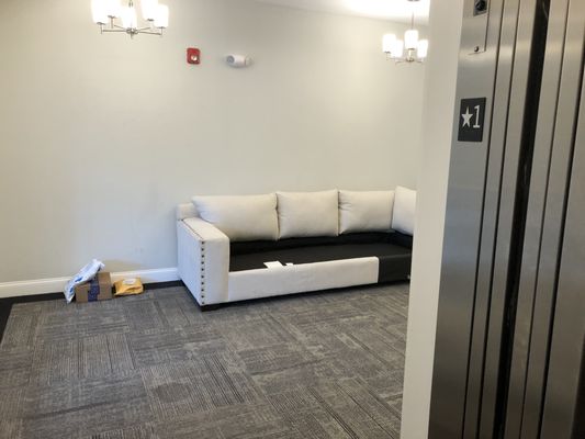 couch thrown away in LOBBY of a luxury hotel with very high rent