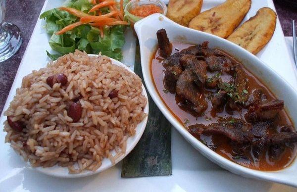 Rice and beans with side of plantains and source.