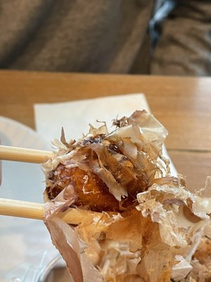 The takoyaki ball hiding under the bonito flakes. Delicious