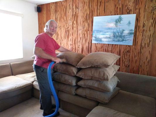 Rick cleaning cushions on a sectional.