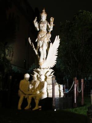 view, at night, of sculpture outside Embassy, lit with spotlights