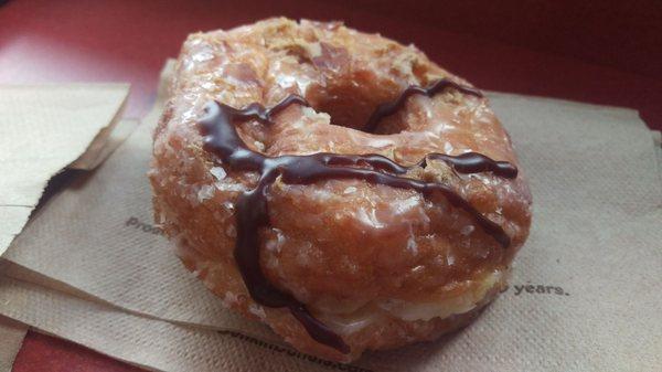 Peanut Butter Delight Croissant Donut: A glazed croissant donut filled with peanut butter buttercreme, topped with a chocolate icing drizzle