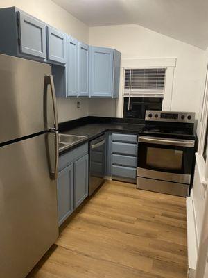 Kitchen renovation new flooring, new tow kick, cabinet refinishing, and new paint on walls.