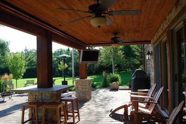 Added patio roof under new deck, ceiling fan, pavers, tv, table and chairs.