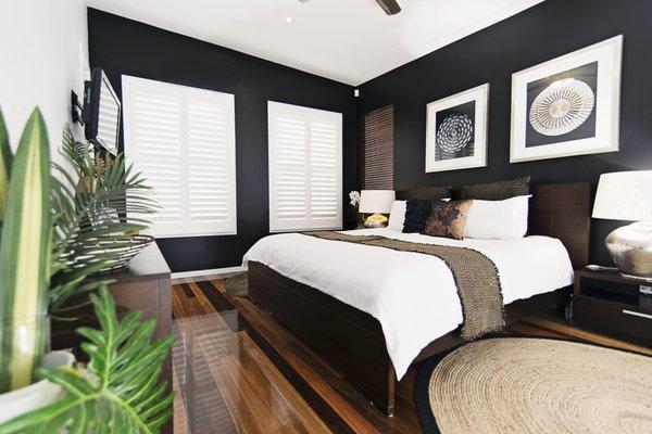 White hinged wood shutters in bedroom.