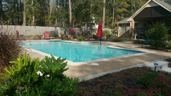 Pool with tanning ledge. Beglared decking (paver deck).