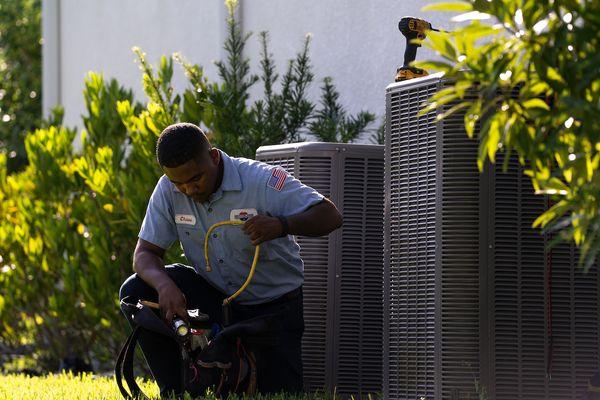 Millian Aire technician fixing a broken AC unit in Trinity Florida