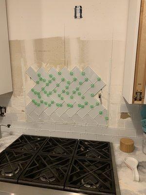 Heringbone pattern subway tile backsplash install.