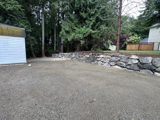 Rock wall using 3-4 man natural stones! Opened up space for a bigger RV and plenty of space for more outdoor activities.