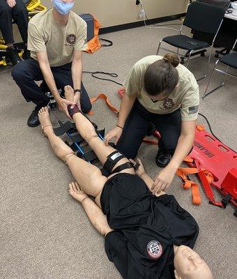 practicing applying a traction splint as part of a hands-on skills scenario