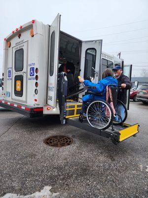 A driver helping a passenger onto a Whitley County Transit bus