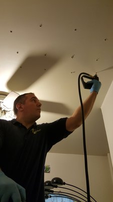 Sal applying Termiticide Foam to a closed ceiling.