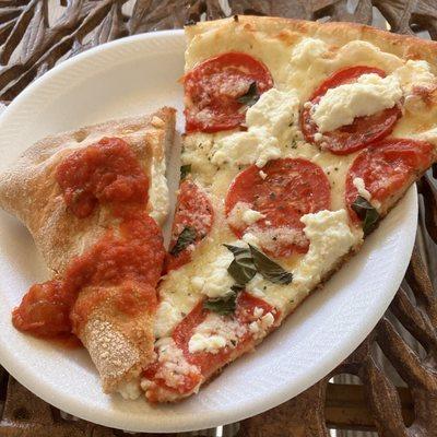 Left: a quarter of a cheese calzone. Right: slice of white pizza (no red sauce) with fresh roma tomatoes, basil, and ricotta.