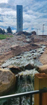 Water cascades from top of hill down to pond