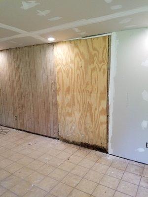 Plywood added over a rotted wall. Water is leaking under rotted bottom plate as you can see the wet bottom. This was covered with sheetrock