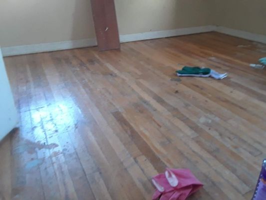 BEFORE Deep Clean- wood flooring is coated with debris, paint and dirt