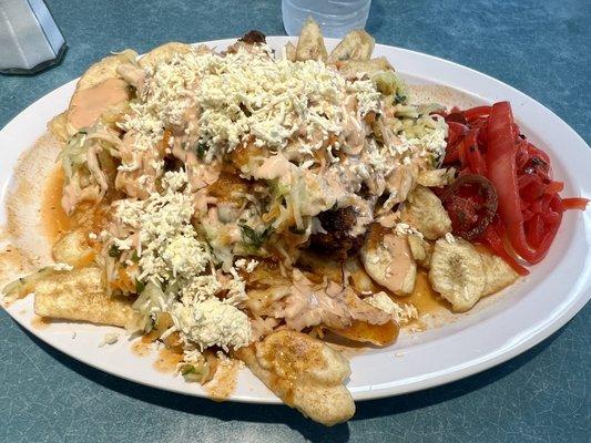 Pollo Frito con Tajadas: a fried chicken and plantain dish with slaw on top and pickled onions on the side. Very tasty!