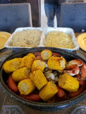 Crab bake w/ corn, shrimp, sausage, potatoes and served with garlic noodles regular and Gluten-free