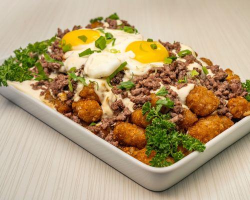 Loco moco tots with creamy sauce and 2 sunny side eggs