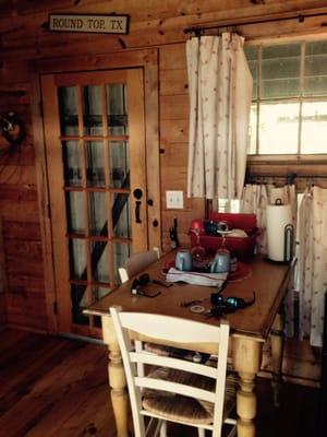 Common area in the cottage. Small table with microwave, refrigerator stocked with bottled water, and coffee maker.