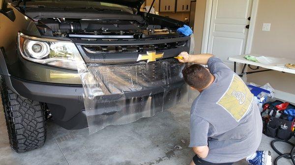 One of our installers customizing our Stealth film on the grille of a Colorado