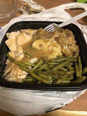 Turkey dinner with string beans, potato mash, stuffing and gravy.