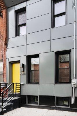 Our real estate investments include optional design help, like this modern exterior and pop of yellow color.