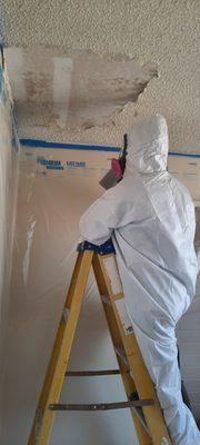 Removing asbestos in proper PPE