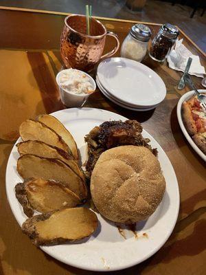 Barbecue pulled pork sandwich with baked potato fries.