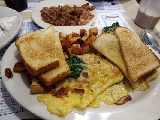 Popeye omelette with spinach, mushrooms, onions, tomatoes, and cheese