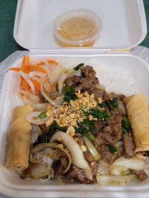 Vermicelli noodles with stir fry beefand egg rolls.