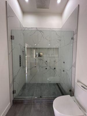 Frameless hinged shower glass panel with fixed-lite.