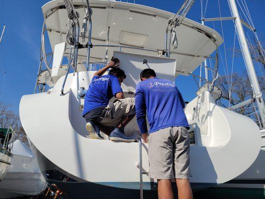 The guys working together to make sure every inch is clean, even the transom storage