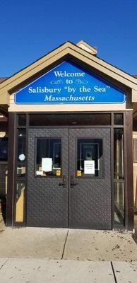 Mixed messages here: "Welcome to Salisbury 'by the Sea' Massachusetts" on the cheerful blue sign, and "OPEN DAILY 9 AM TO 5 PM" on the door.