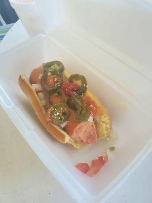 A cold hotdog with pickled jalapeños.