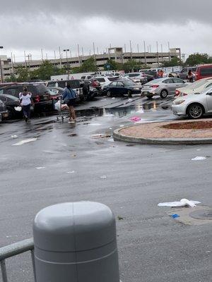 Filthy parking lot littered with trash because trash bins are never emptied