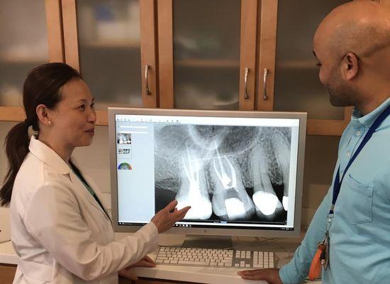 Dr. Young showing a X-ray image after root canal completion to a patient.