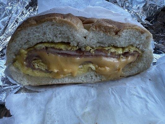 Spiced ham, egg and cheese with a black pepper on a roll.