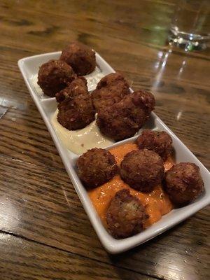 Tapas. fried olives in a romessco, fried artichokes in a creamy sauce, and fried crab cake bites in a cucumber sauce