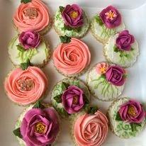 Beautiful floral cookies adorned with pink and purple buttercream roses, offering intricate designs ideal for special events.