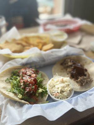 Buffalo chicken taco and pork taco with baked beans and slaw on side